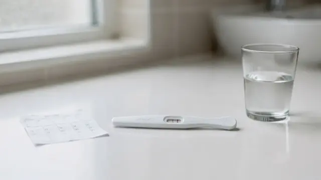 Schwangerschaftstest mit Kalender auf einem Badewannenrand zum Thema 25 mIU/ml Schwangerschaftstest