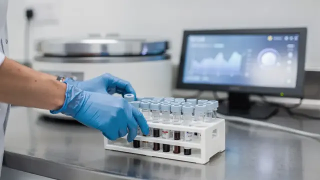 Bluttest in der Schwangerschaft im Labor mit Probenröhrchen und Handschuhen